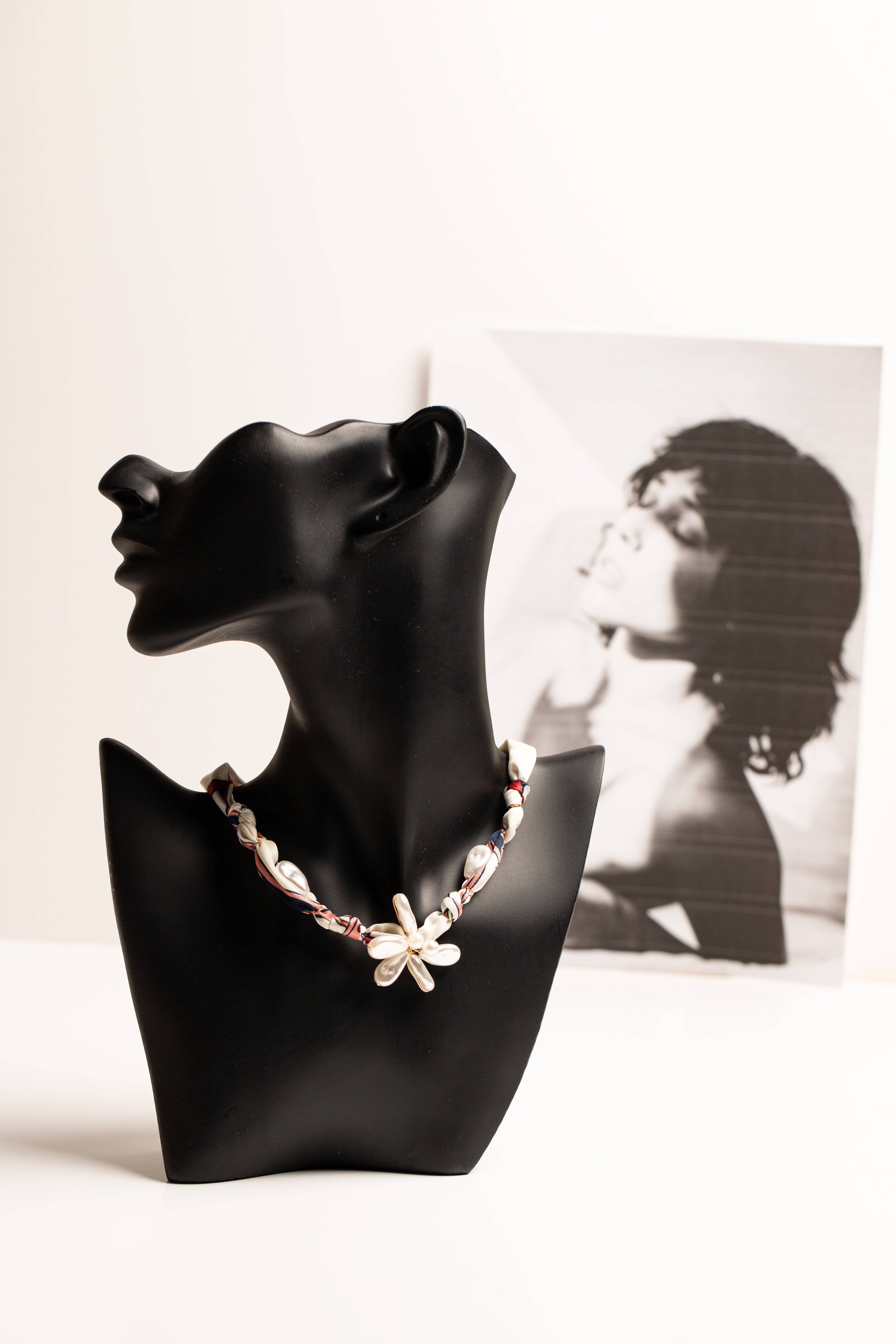 Necklace on a black mannequin bust with a blurred background